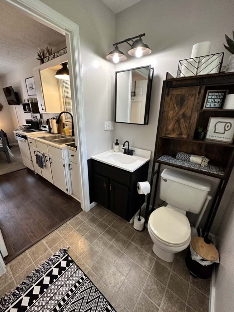 Bathroom with vanity, mirror, and over-toilet shelving