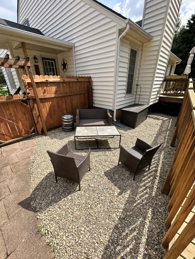 Courtyard wicker seating set on gravel patio in daylight