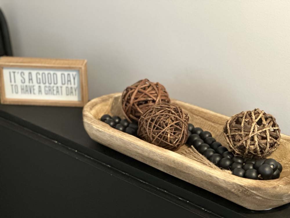 Decorative wood bowl with rattan balls and accent sign