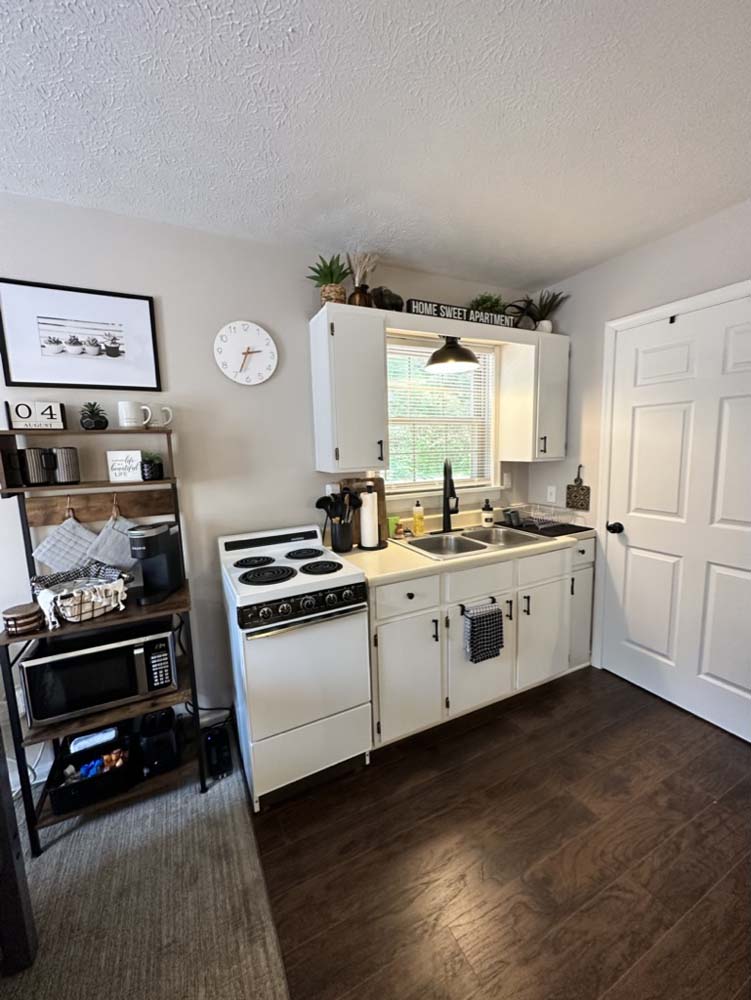 Kitchen with white cabinets, electric stove, and coffee shelf
