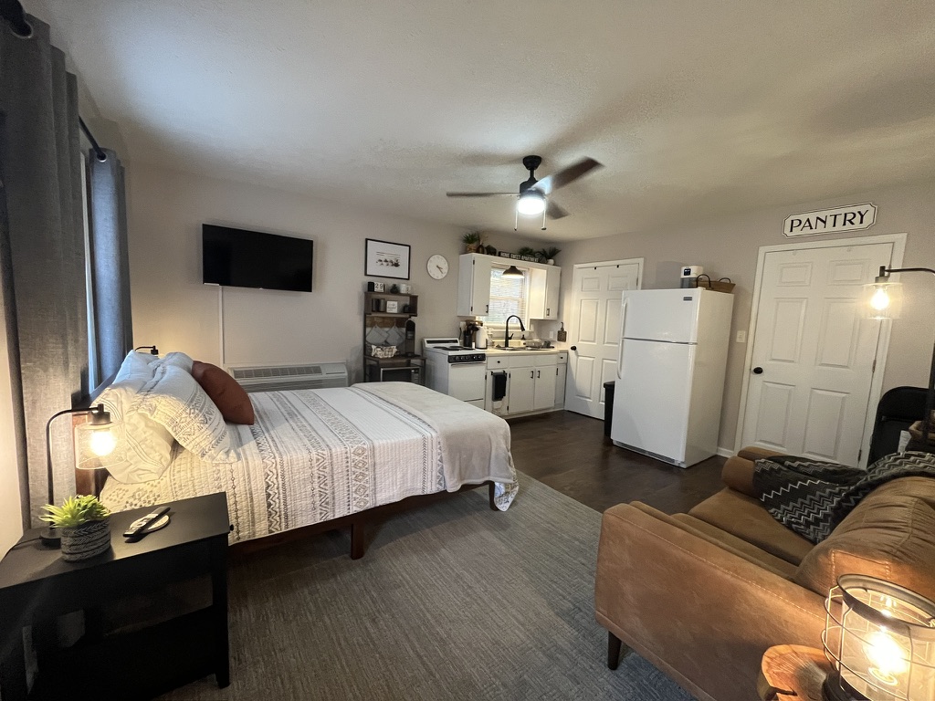 Studio living and kitchen area with pantry sign and warm lighting